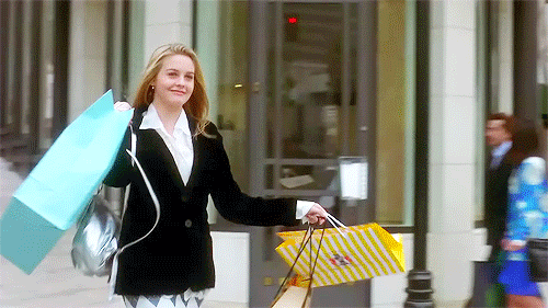GIF from the movie "Clueless" with Alicia Silverstone carrying a lot of shopping bags